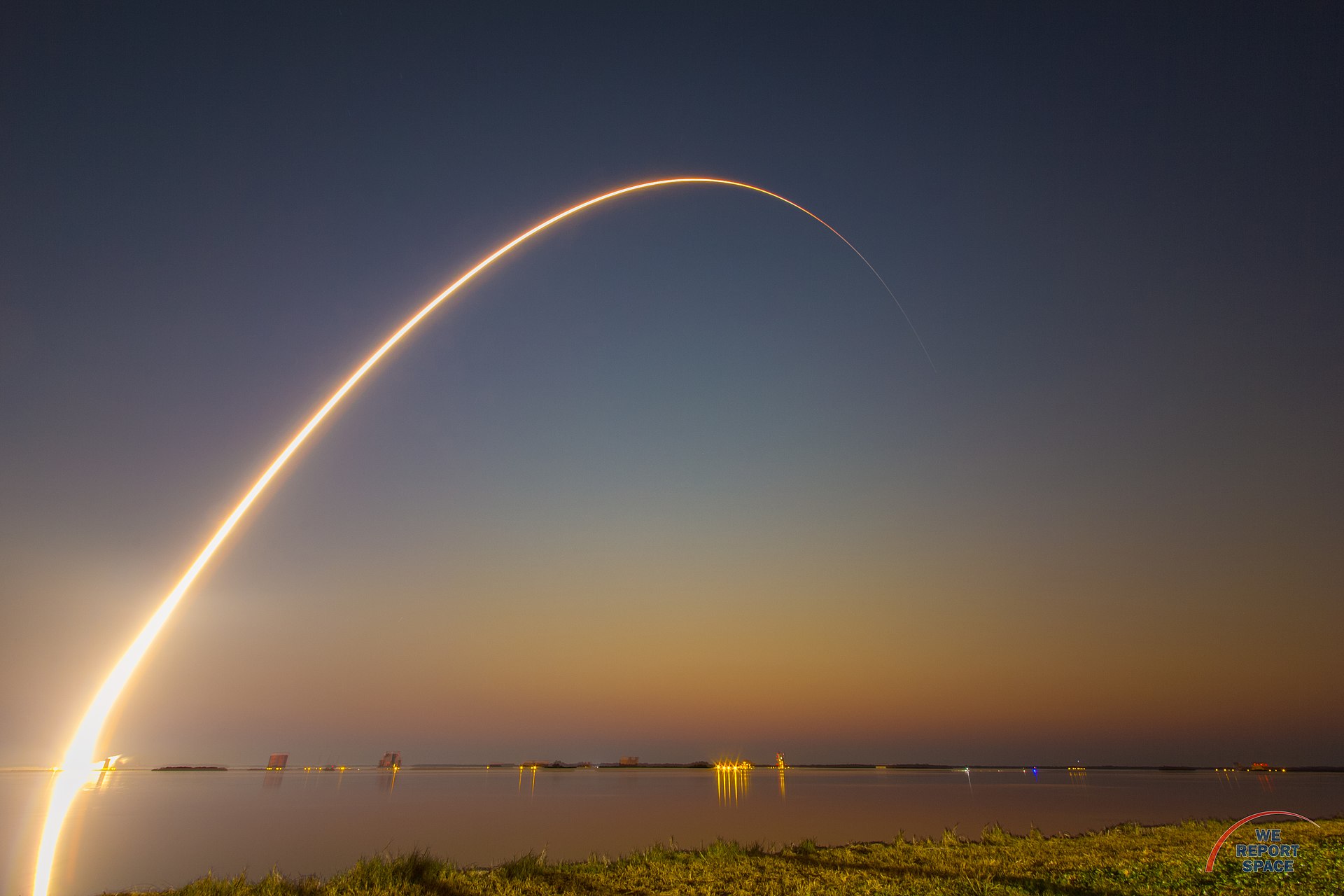 A long exposure shot of a rocket being launched, the streak of light following its arc is visible due to the technique used to photograph it.