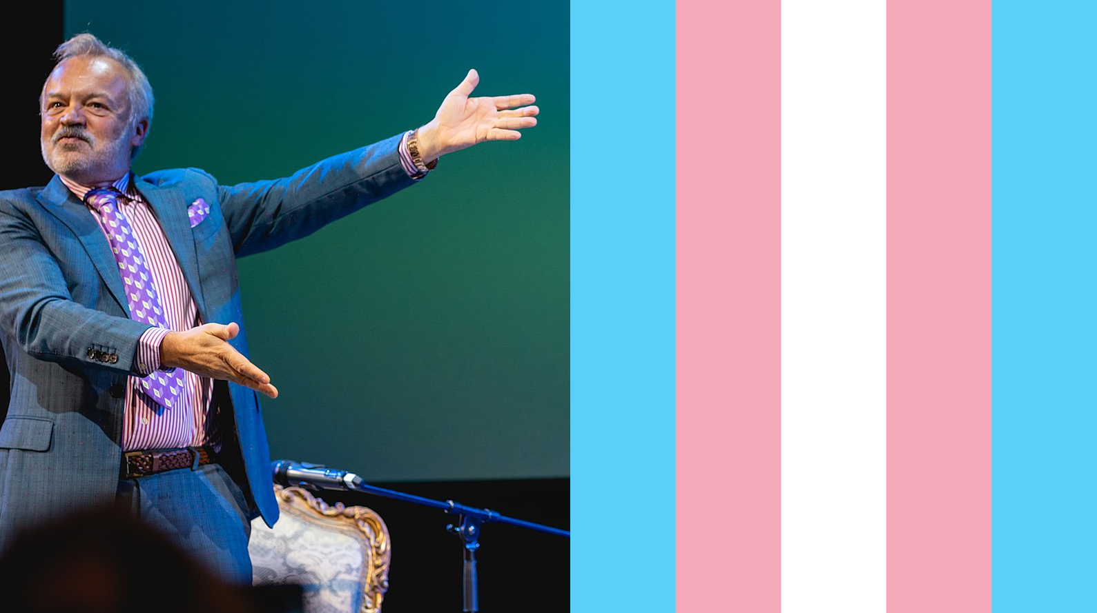 An image of Graham Norton gesturing towards a trans flag that I photoshopped in in place of Joan Collins who was originally on stage with him. This...