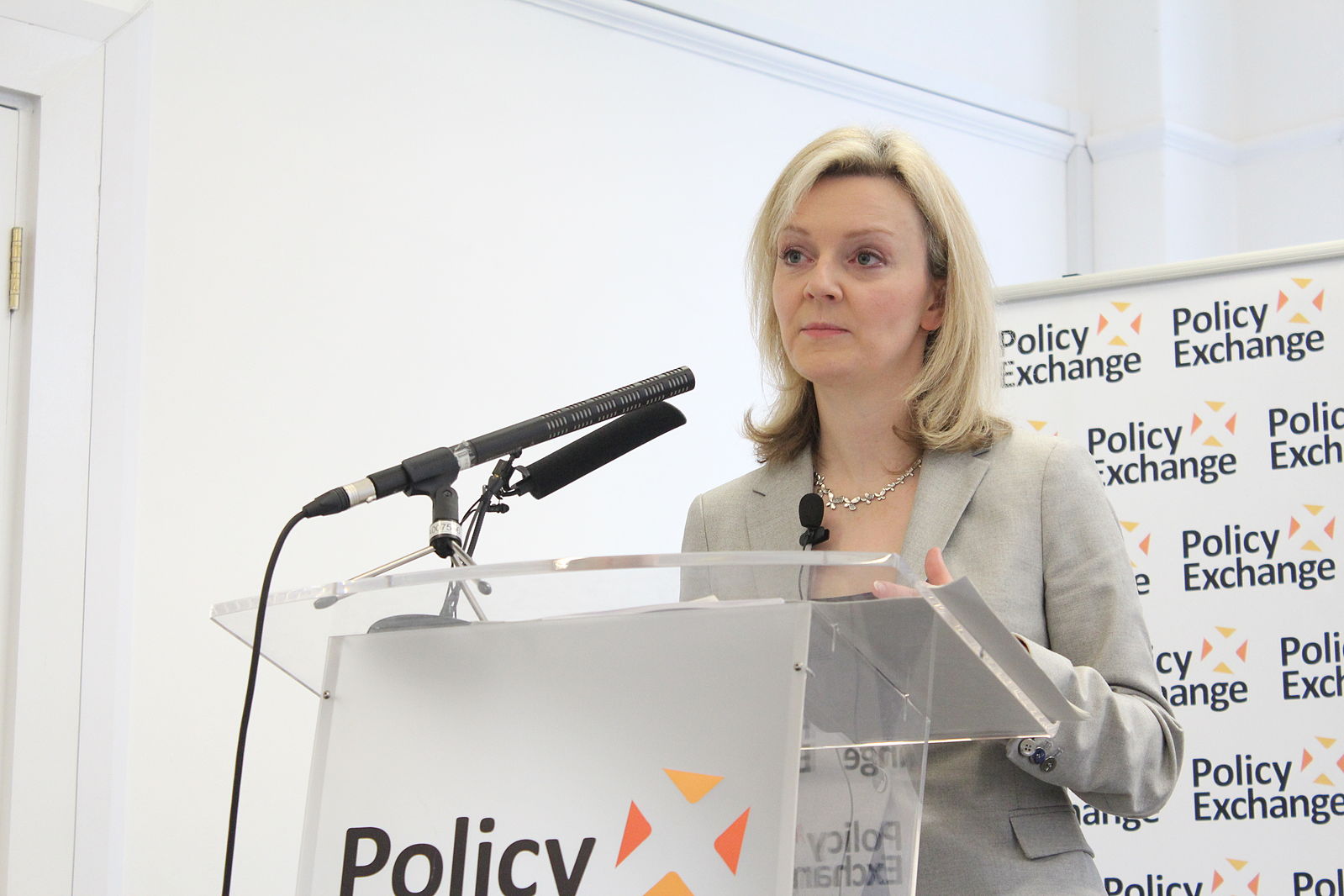 Liz Truss giving a speach at a Policy Exchange meeting. Liz Truss, as head of GEO, was tasked with reforming the GRA and trans healthcare