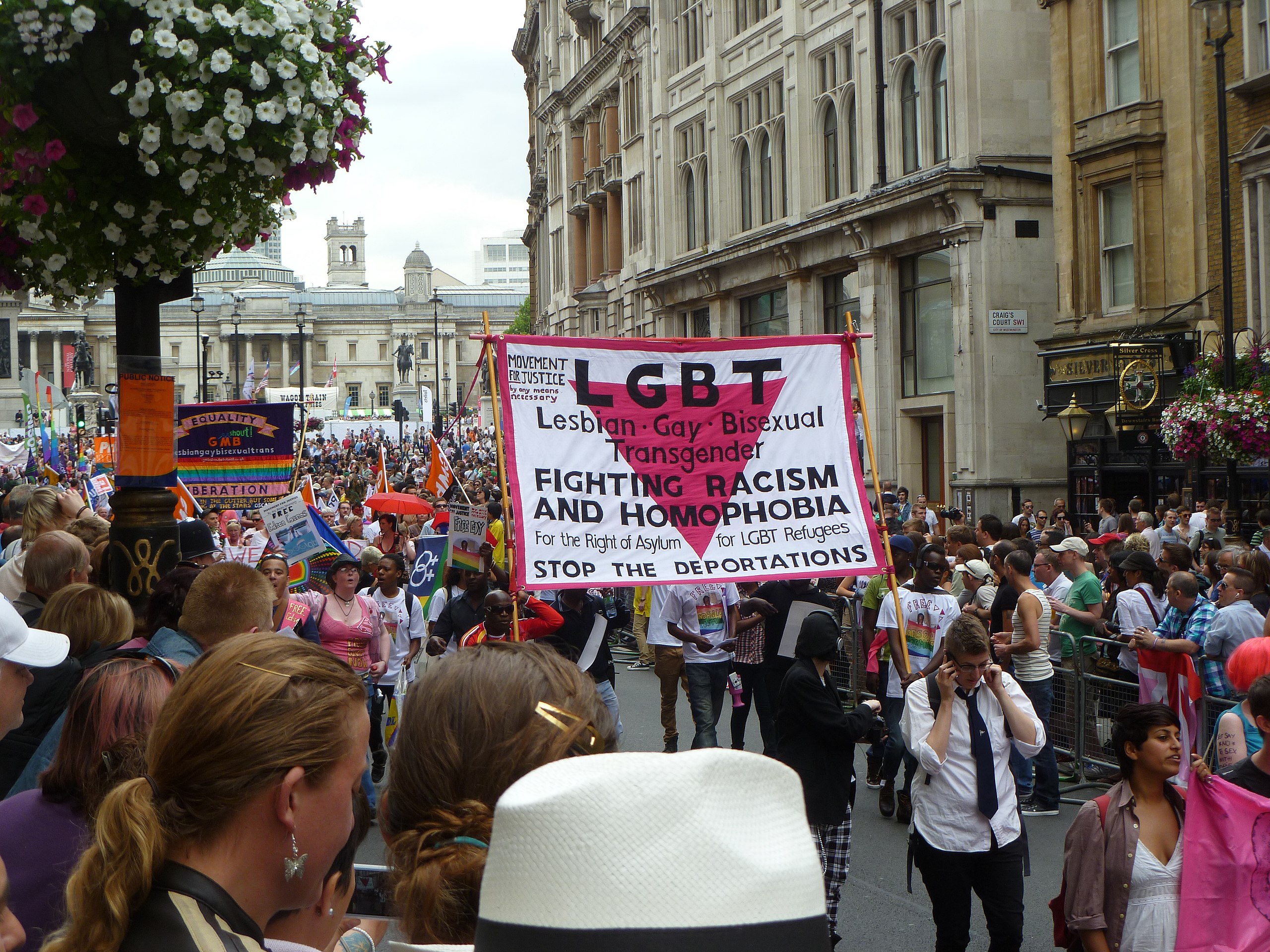 When was T added to LGBT? A protestor holds a sign in 2011 at a London Pride event reading: "Lesbian, Gay, Bisexual and Transgender. Fighting Racis...
