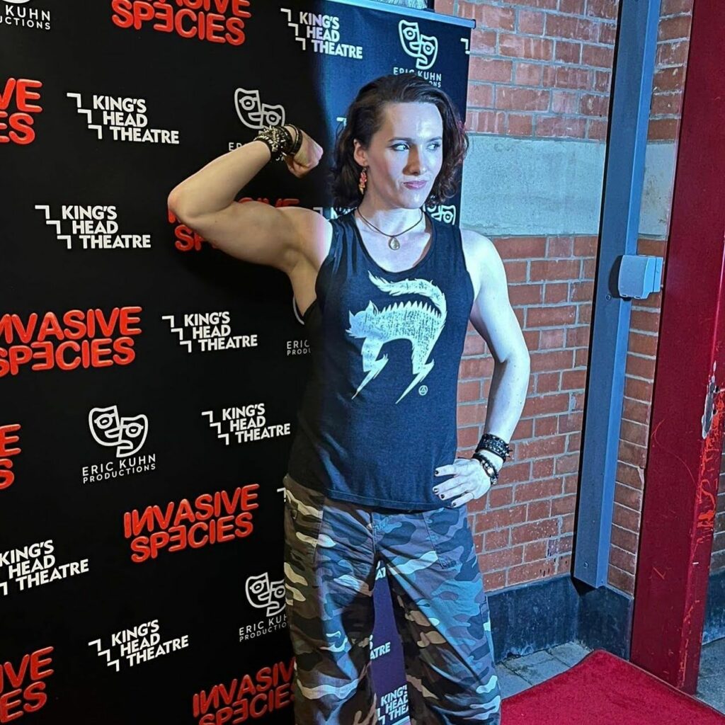 A photo of Abigail Thorn flexing her biceps on a runway