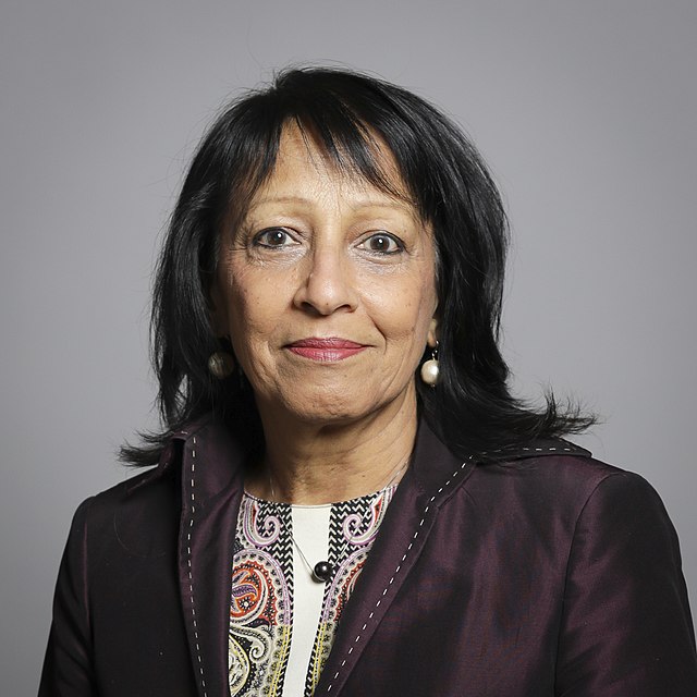 A photo of Baroness Kishwer Falkner in a brown jacket against a grey gradient background