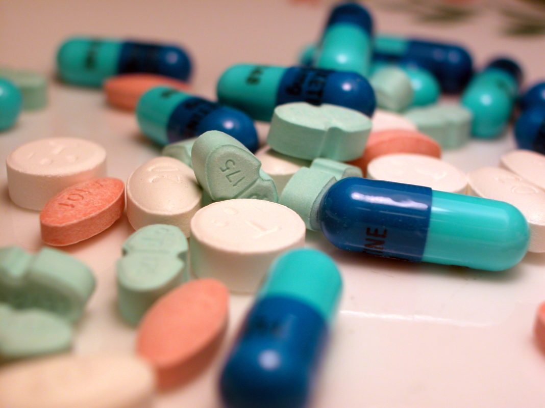 Various coloured pills on a table, meant to represent medication or in this case bridging hormones. Source; MorgueFile