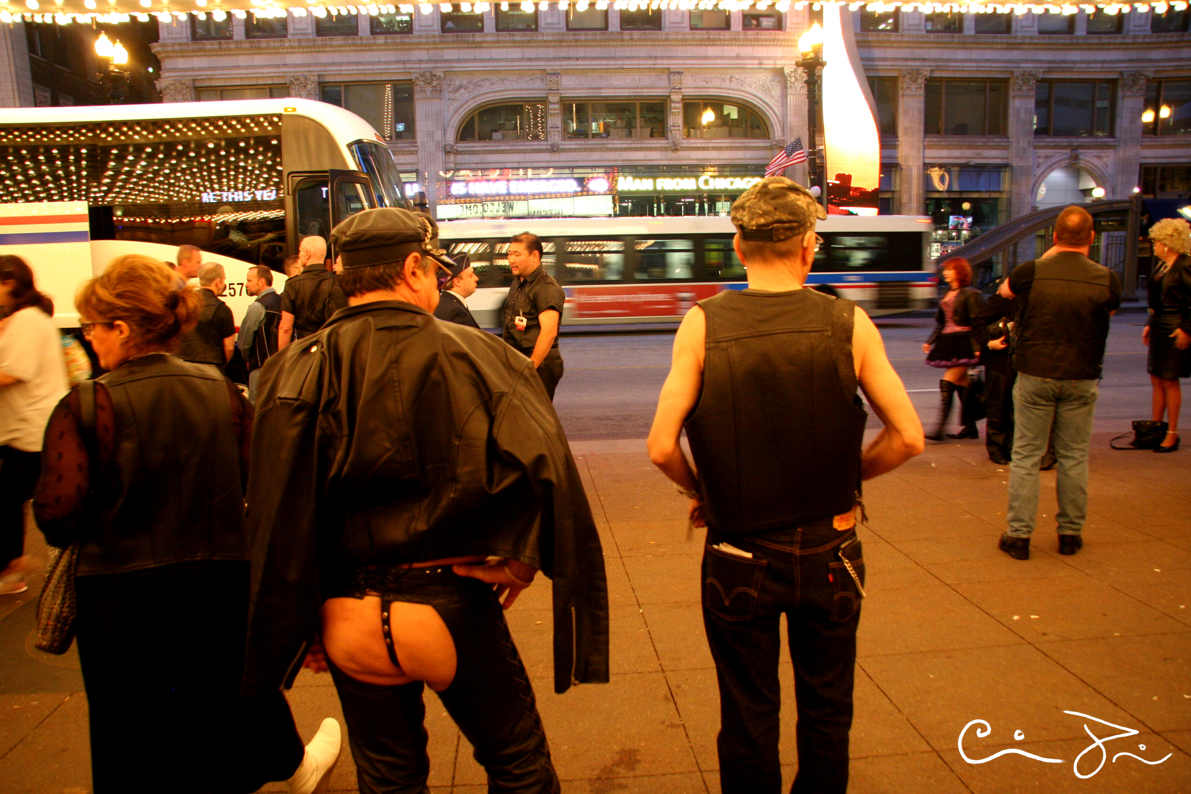 A representation of trans joy via International Mr Leather #29, at the Chicago Theater, 2007. The photo shows men wearing various assortments of leather, one has his butt cheeks on display in assless chaps.