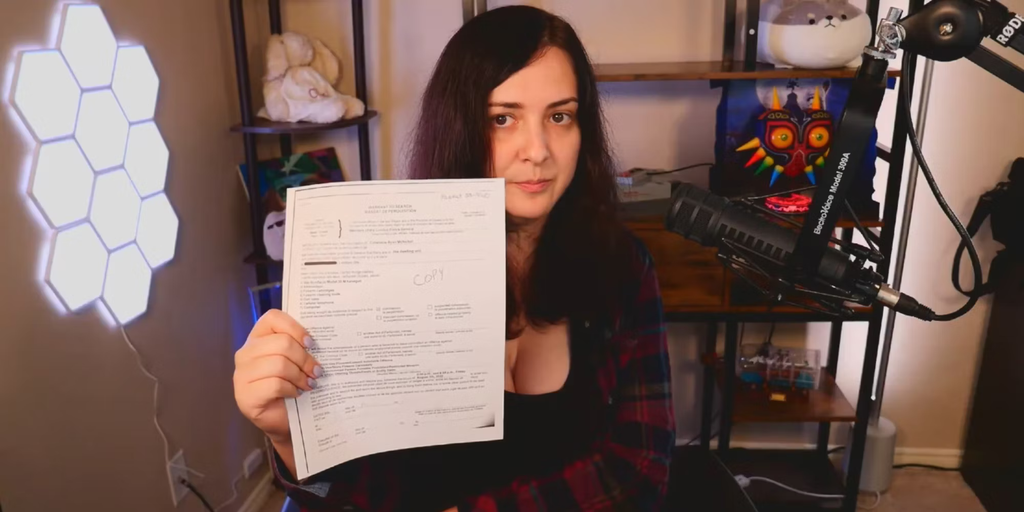 A photo of Keffals in her room holding a police document