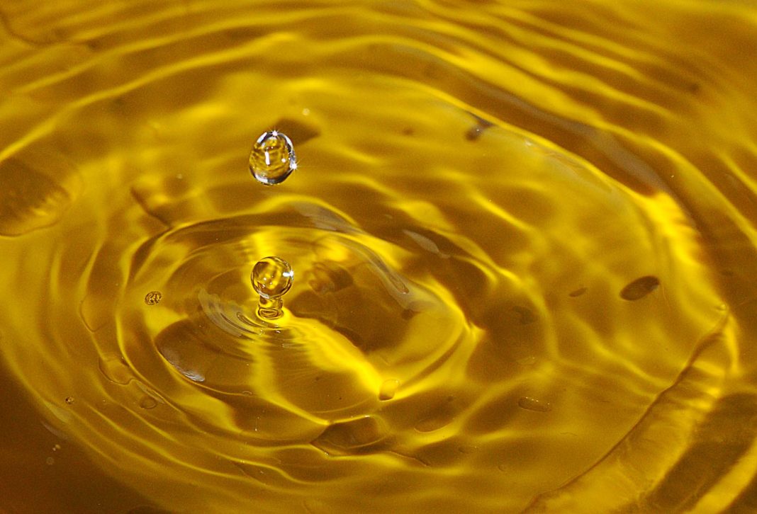 water droplets falling into a puddle of yellow water causing ripples; used in place of images to signify the piss protest against ehrc.