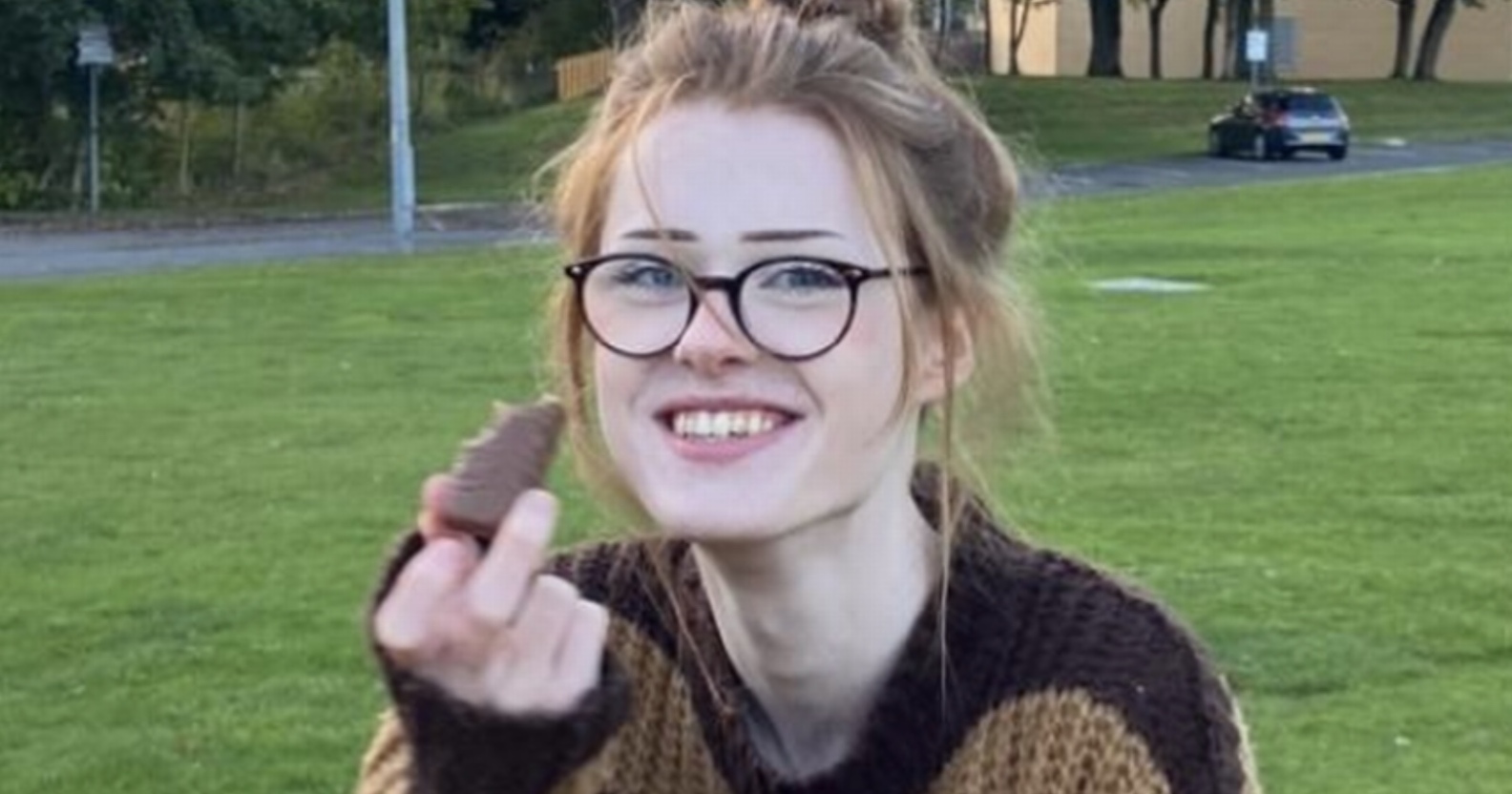 Brianna Ghey, the 16 year old transgender girl who has been murdered, in the photo she sits on a bench wearing a baggy jumper eating a chocolate bar and smiling