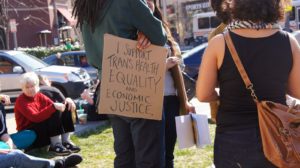 A photo from a rally in 2013; someone holds a sign reading "i support trans health equality and economic justice" photo by Ted Eytan source: Wikimedia. Absolutely no relation to Helen Webberley.