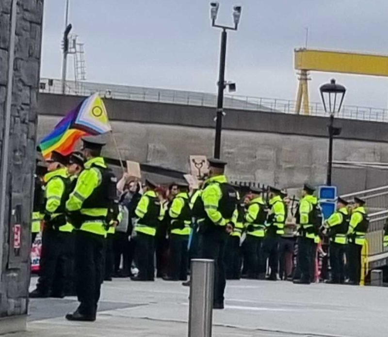 Police stand in front of protestors at Posie Parker's anti-trans rally in Belfast, 16 April 2023