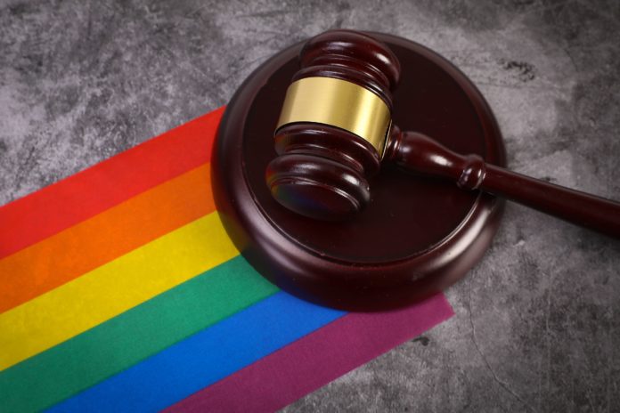 Are gender critical beliefs protected in law? No! A picture of a gavel against a rainbow flag by Jernej Furman via Wikimedia Commons